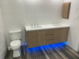 Modern bathroom double vanity featuring custom wood cabinets with white quartz countertop and dual undermount sinks by Polymita Woodcraft