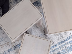 Close-up of an elegant, finished wooden side table featuring intricate, exposed dovetail joinery securing the legs to the tabletop.